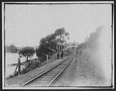 Pedestrian bridge over railroad track beside pond, Tasmania, 1895