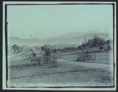 View of city from park with mountains in background, Tasmania, 1895