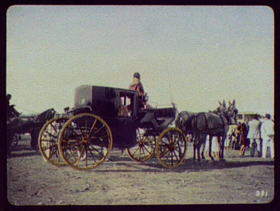 Black coach with gilded wheels drawn by two horses, India, 1895