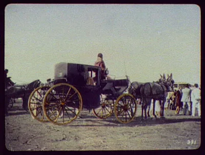 Black coach with gilded wheels drawn by two horses, India, 1895