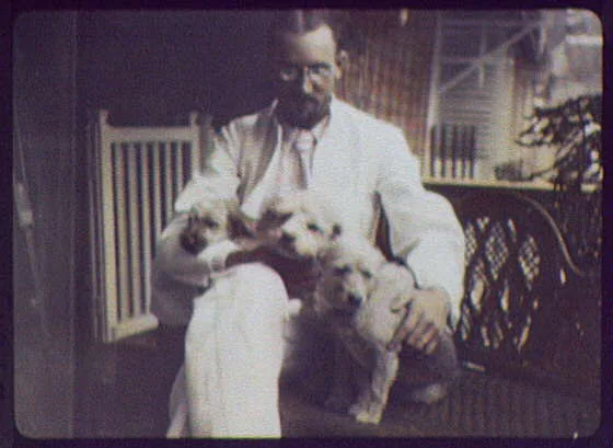 Indian puppies  - man holding 3 puppies on his lap, 1895