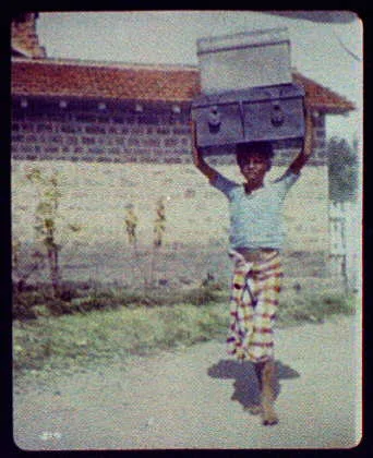 Delhi (?) - young boy carrying two large trunks on his head, India, Delhi, 1895