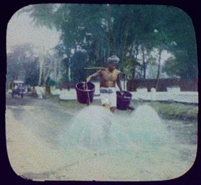 Batavia - man watering the street with large watering cans hanging…, Java, Batavia, Indonesia, 1895