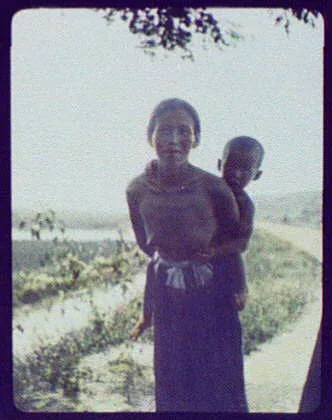 Bare-breasted mother carrying small boy, Java, Indonesia, 1895