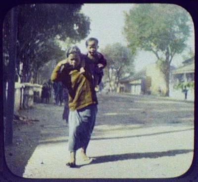 Woman carrying small boy on street in Buitenzorg (Bogor), Java, Bogor, Indonesia, 1895