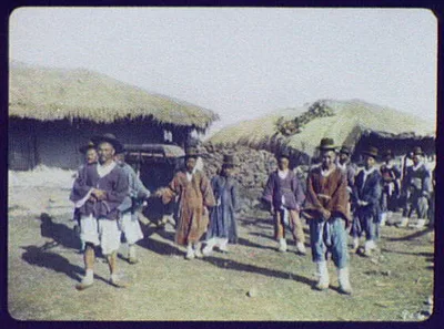 Governor and escort passing through provincial village in covered…, Korea, 1895