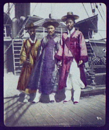 Three Korean gentlemen posed on deck of ship, 1895