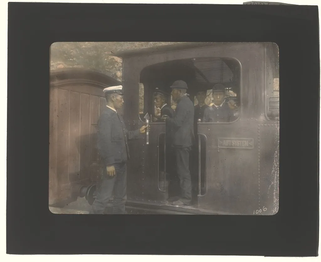 Five Japanese men on railroad locomotive, 1895
