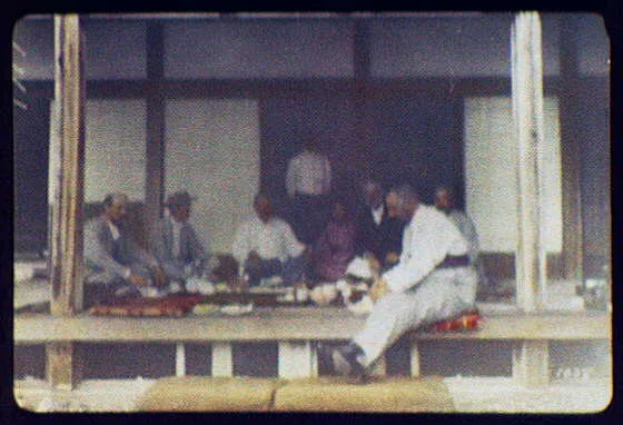 WTC [i.e. World Transportation Commission] dining on porch of building, Japan, 1895