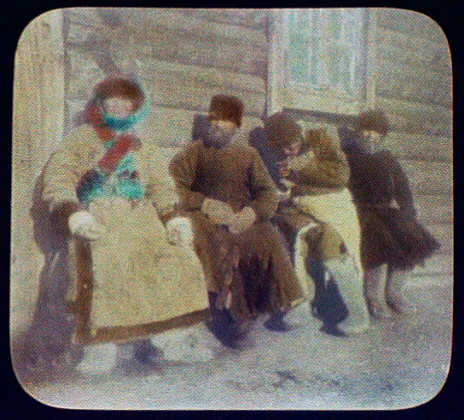 Four convicts sitting against house, Siberia, 1895