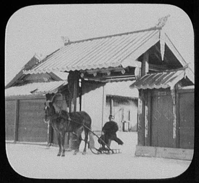Horse-drawn sledge in gateway of Manchu house across Amur river from…, China, Manchuria, 1895