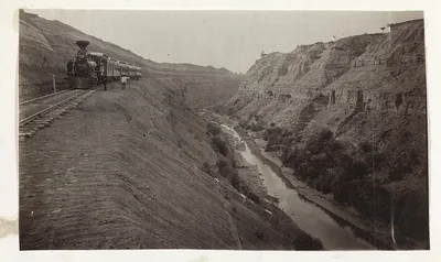 [People inside and outside stopped train alongside a canyon in Mexico], 1883